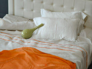 biancheria letto in lino bianco arancio con lenzuola e guanciali