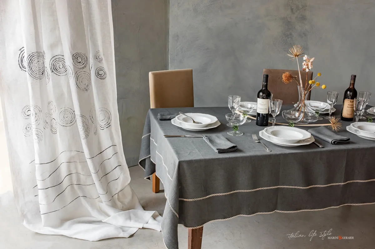 tovaglia di lino grigio antracite con bottiglia di vino fiori tendaggi